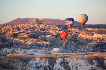 Balloons over Uchisar castle in Cappadocia at sunrise, Turkey