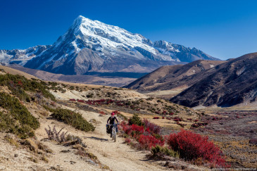 Traveler on mountain bike cycling trail in mountains. Tibet, China