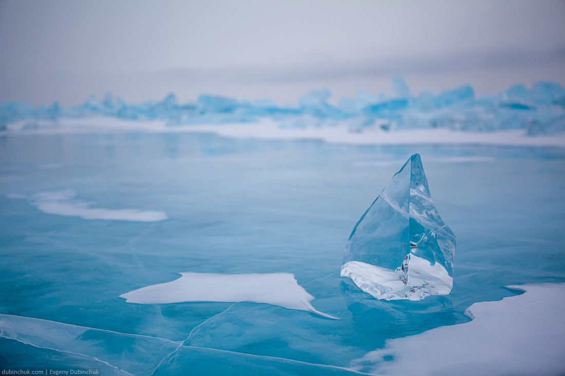 Синяя ледяная глыба на фоне торосов в пасмурную погоду