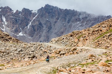 Cyclist at mountain pass. Tien Shan, Kirghizia
