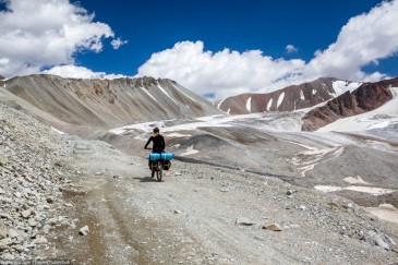 Cyclist in high Tien Shan Mountains near glacier